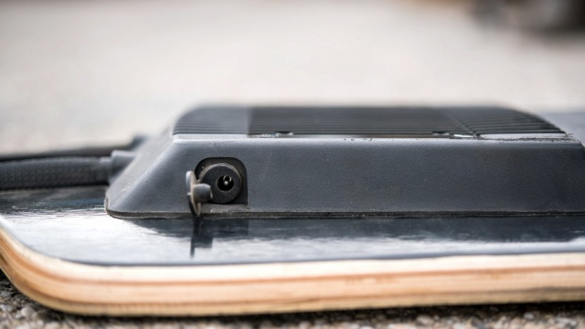 electric skateboard - the charging port and cover of the evolve&#039;s lithium battery pack.