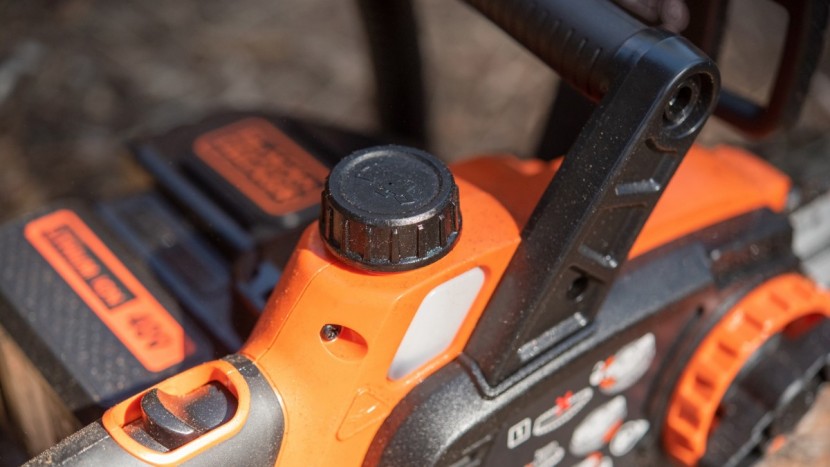 battery chainsaw - the black+decker oil cap is located on the top of the saw body for...