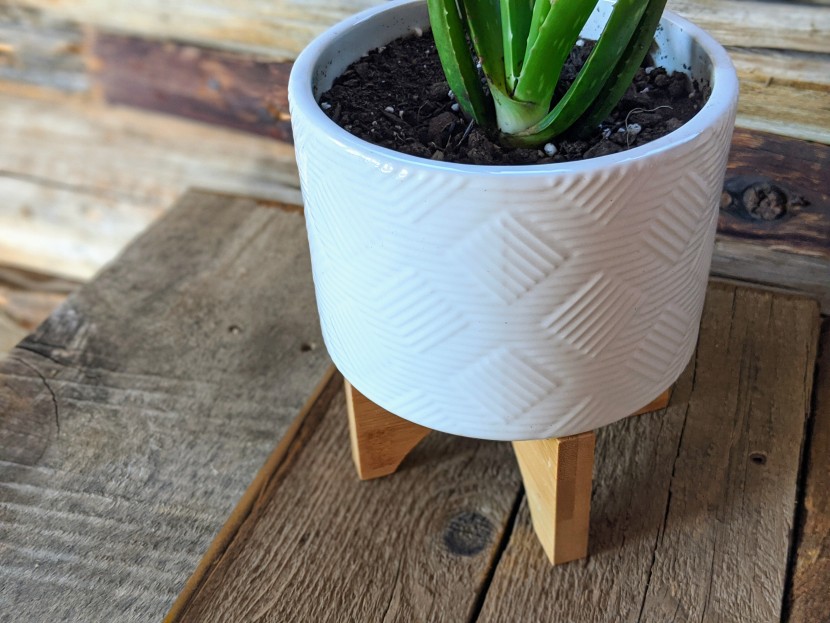 planter - the potey mid-century has a level wooden stand and printed ceramic...