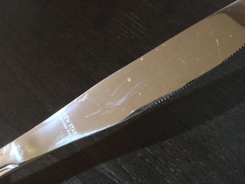 flatware set - scratches and water spots can be seen on this knife blade.