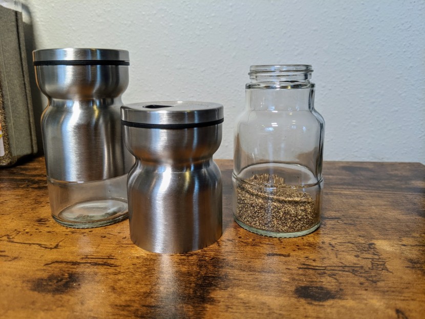 salt and pepper shakers - a metal sleeve covers a glass container on these shakers.