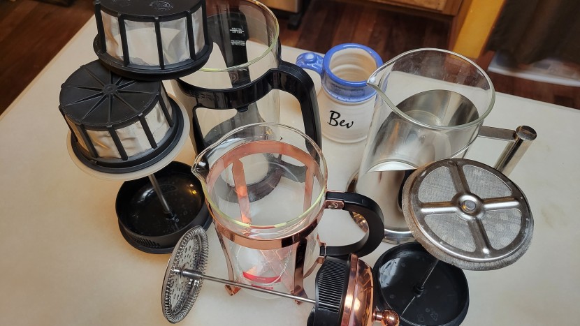 french press - an assortment of glass presses with their filters showing. on the...