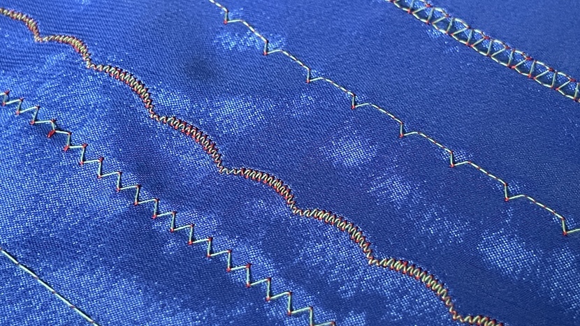 the wrong side of scalloped stitches, showing the top red thread...