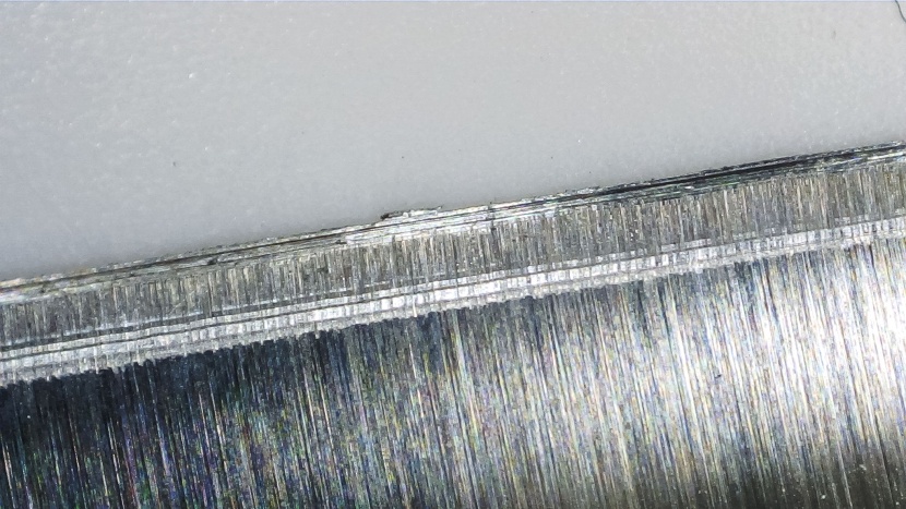 notice the distinct grind marks running parallel to the blade's...